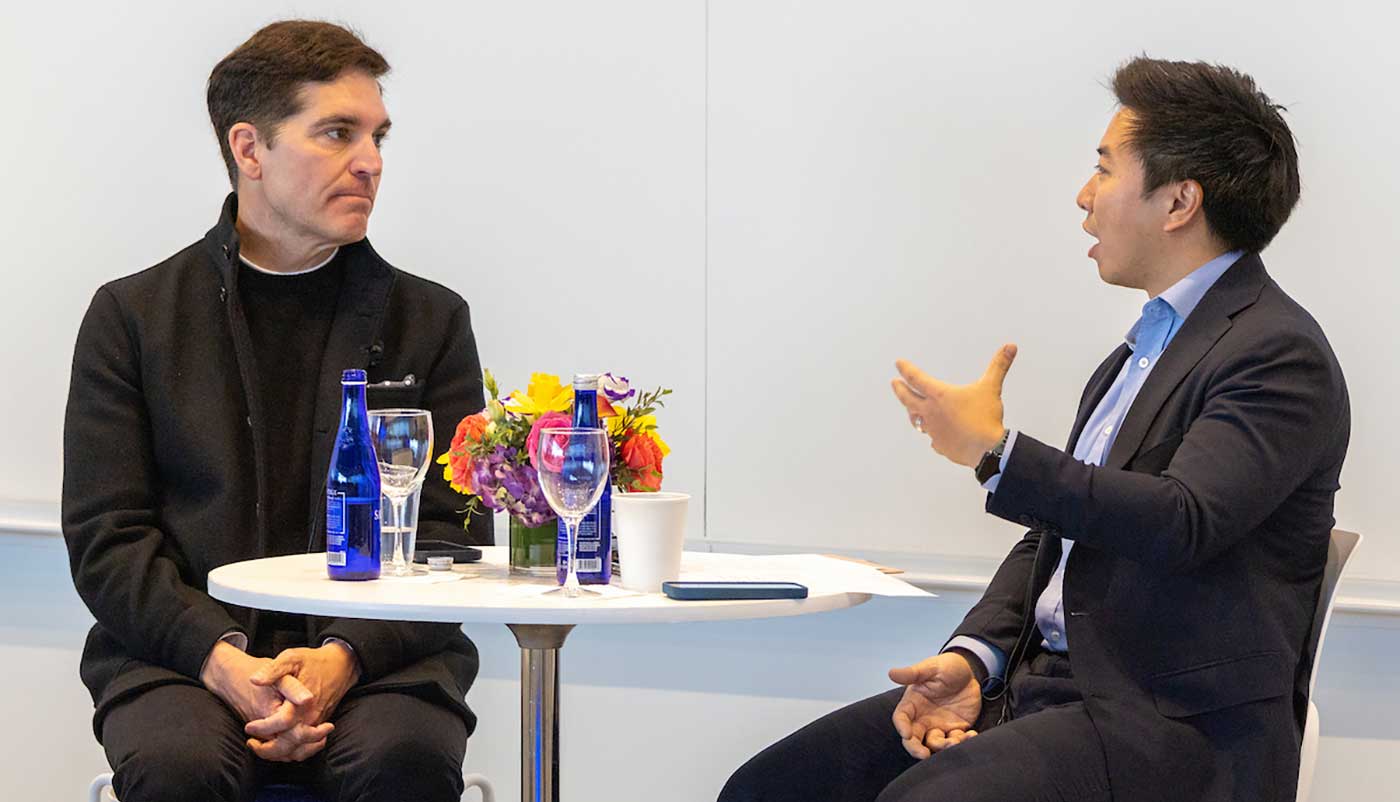 Dan Wang speaking with another panelist at the AI in Media Conference
