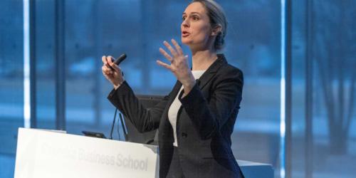 Tuesday, March 4, 2025 AI Summit Satellite Session, “AI in Business: Cutting-Edge Research and Real-World Impact A female presenter addressing the audience at the AI Summit Satellite Session